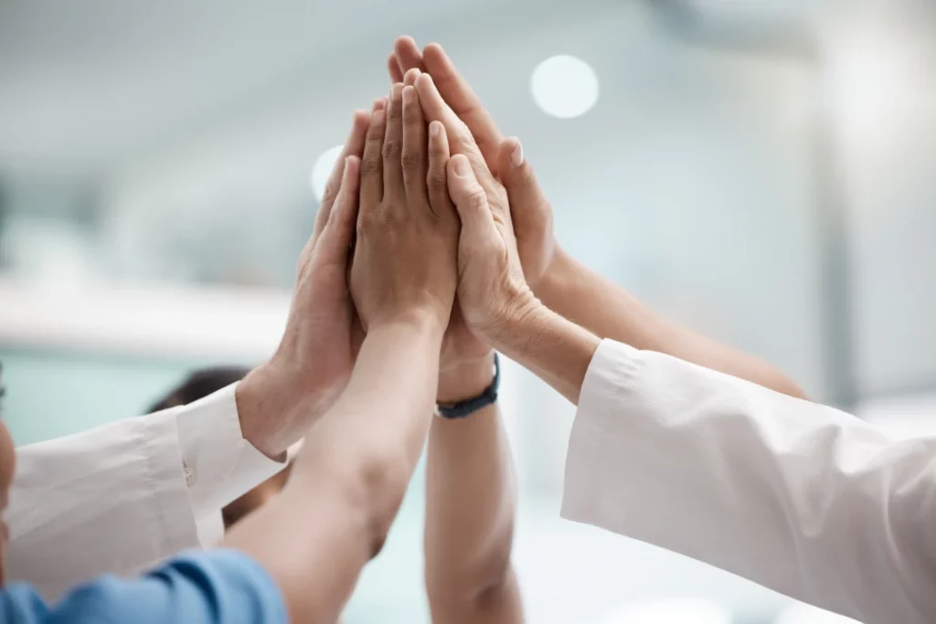 Mehrere Hände geben ein High Five